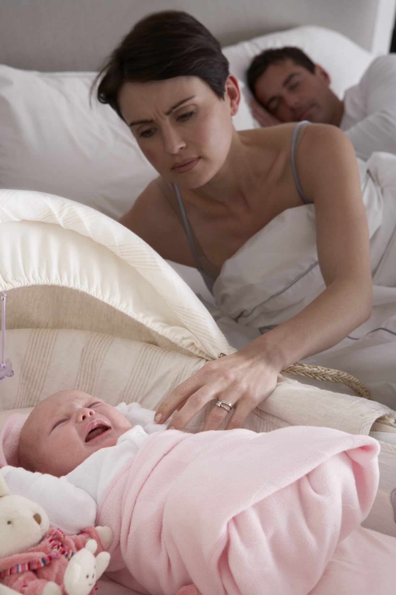 newborn baby sleeping in bed with parents